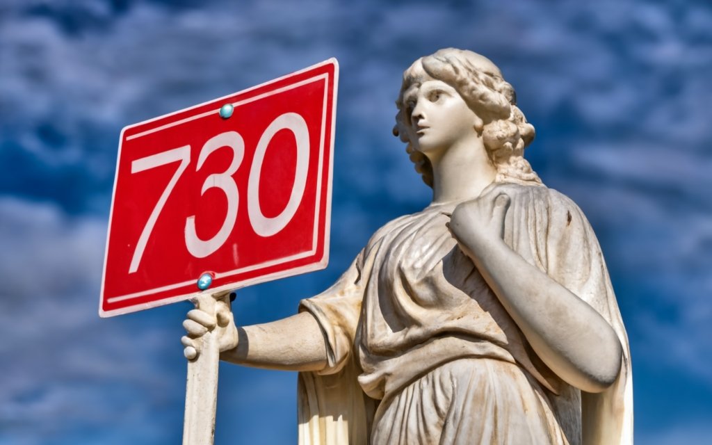 a marble angel statue holding a sign with text 730