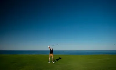 man standing on green grass field playing golf