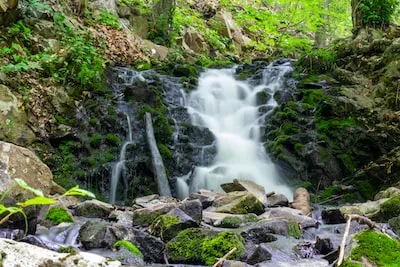 water falls on rocky shore during daytime