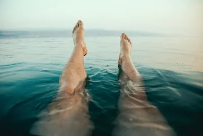 person's legs on water